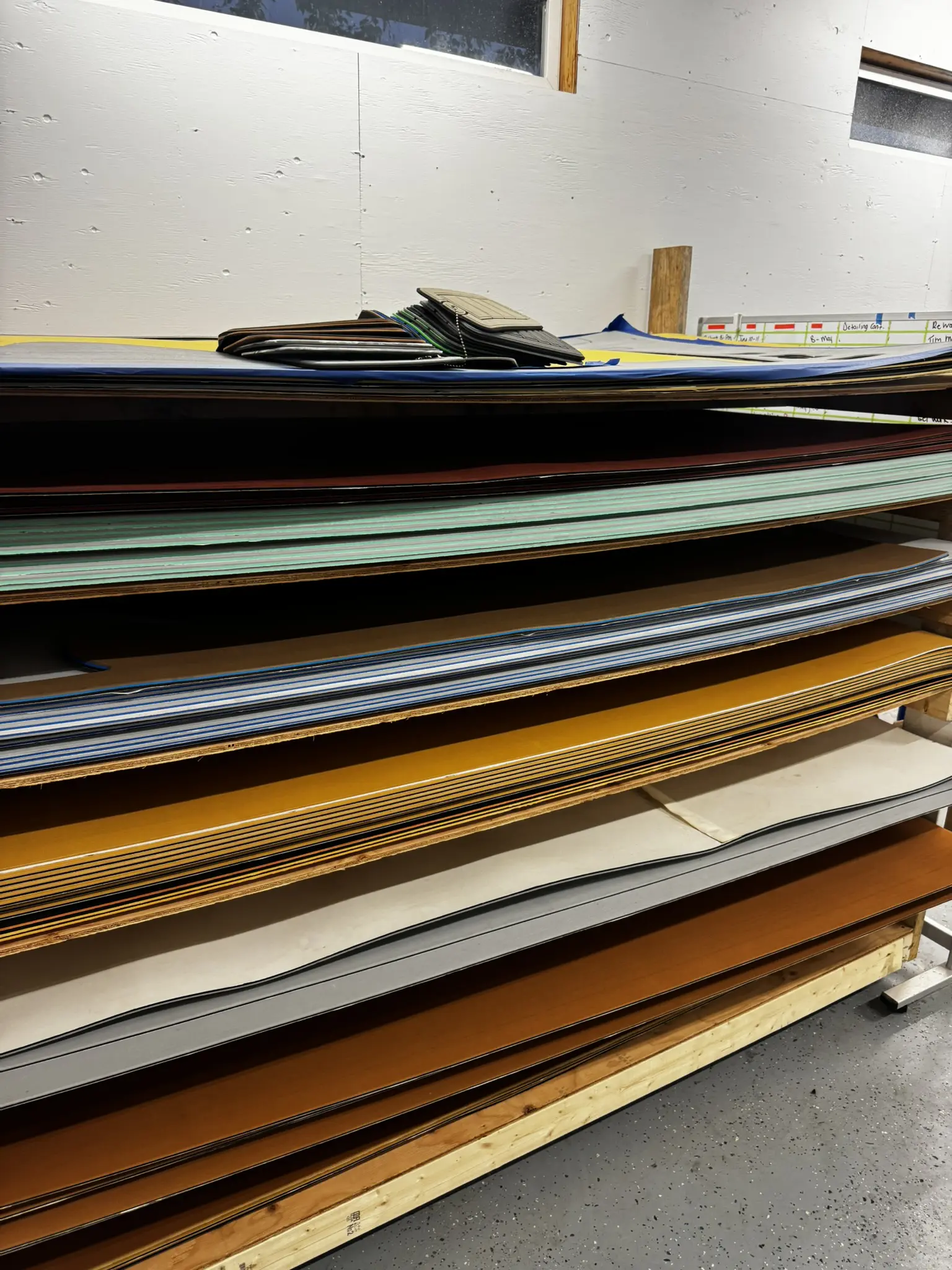 Stacked sheets of colorful materials on shelves.