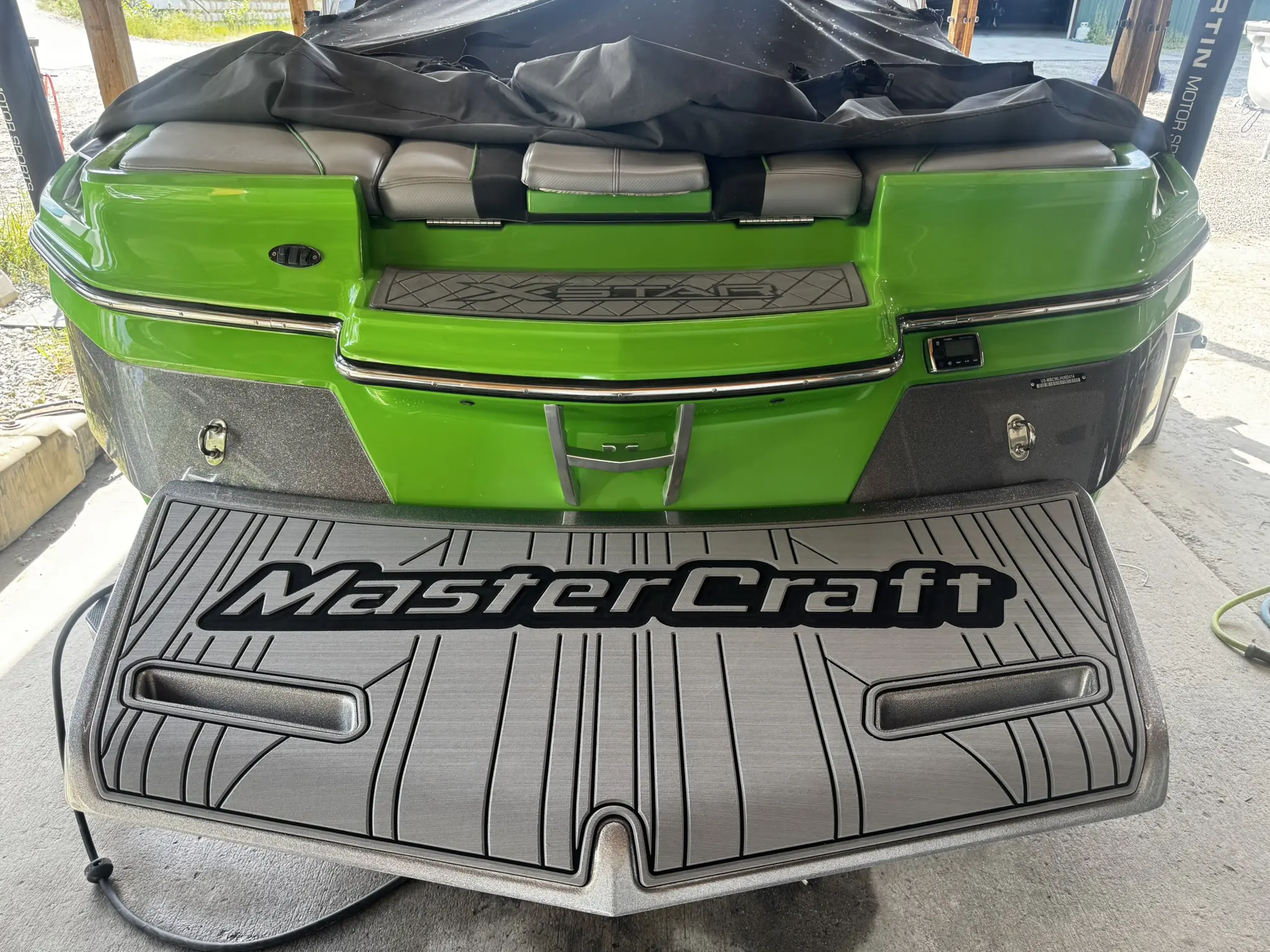 Green MasterCraft boat with gray deck.