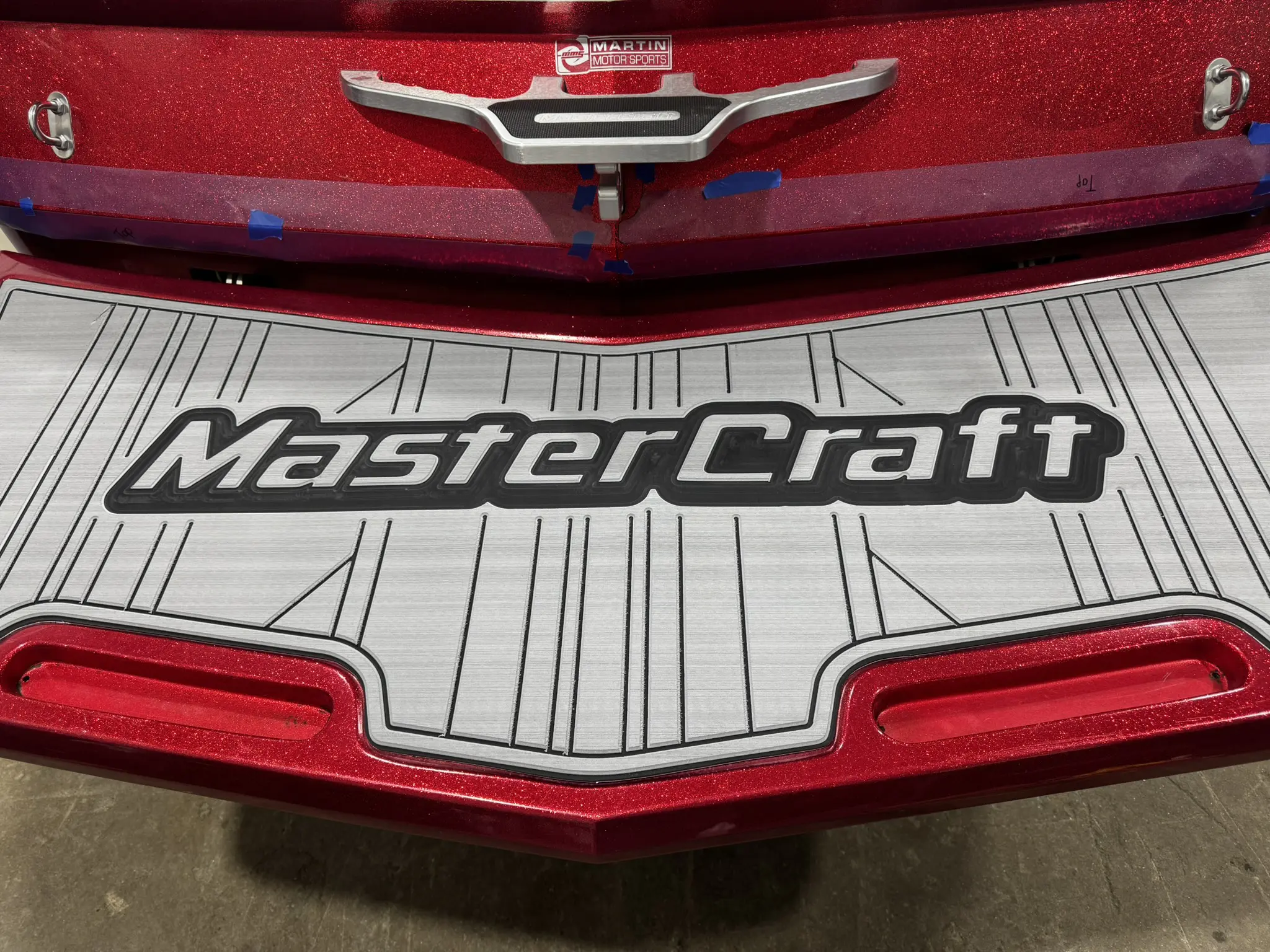 Red MasterCraft boat platform with logo.