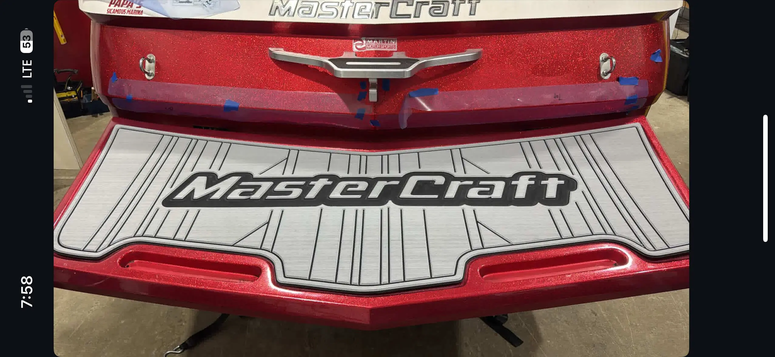Red boat with MasterCraft logo on platform.