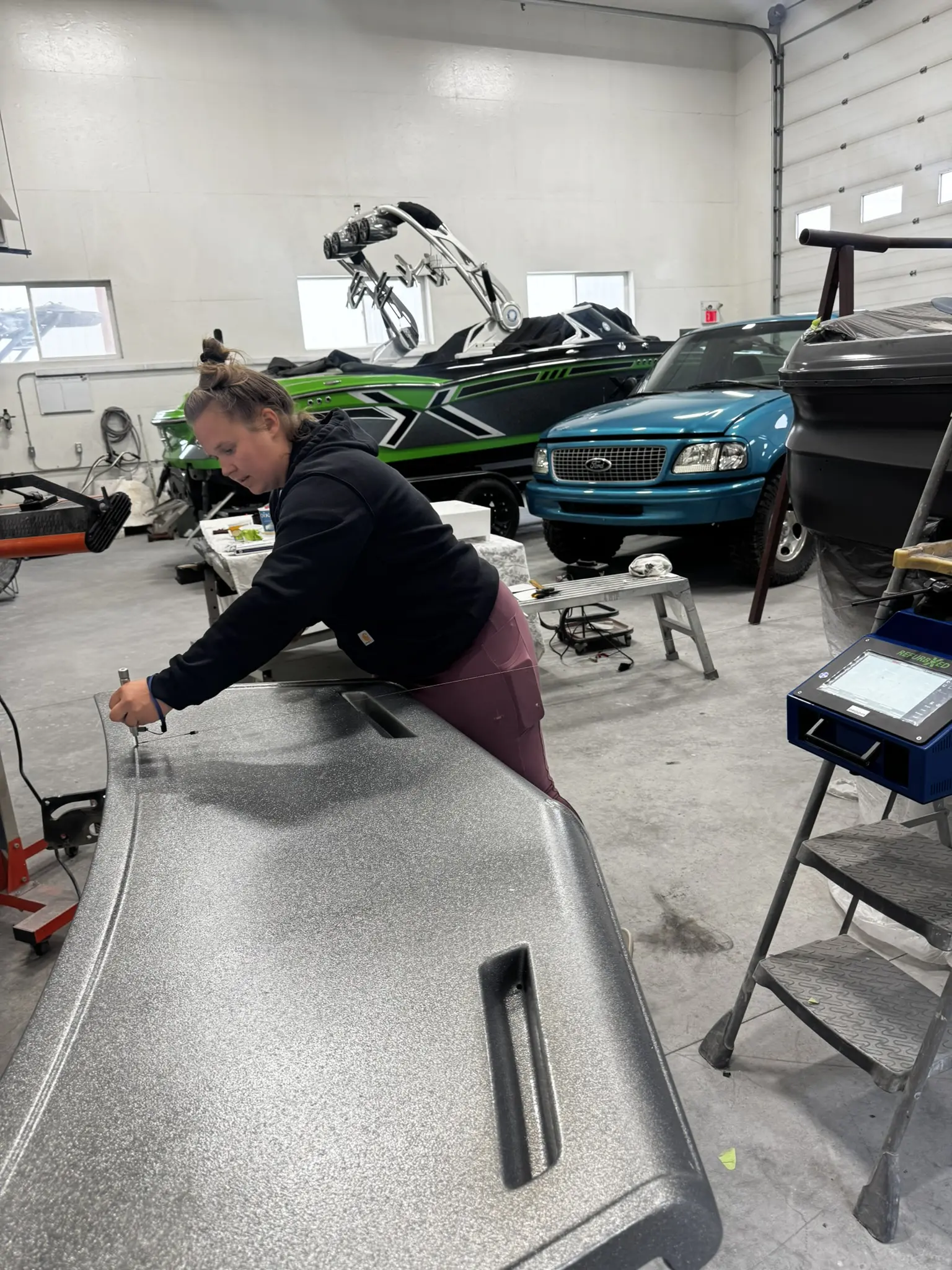 Woman working in a workshop with boats.